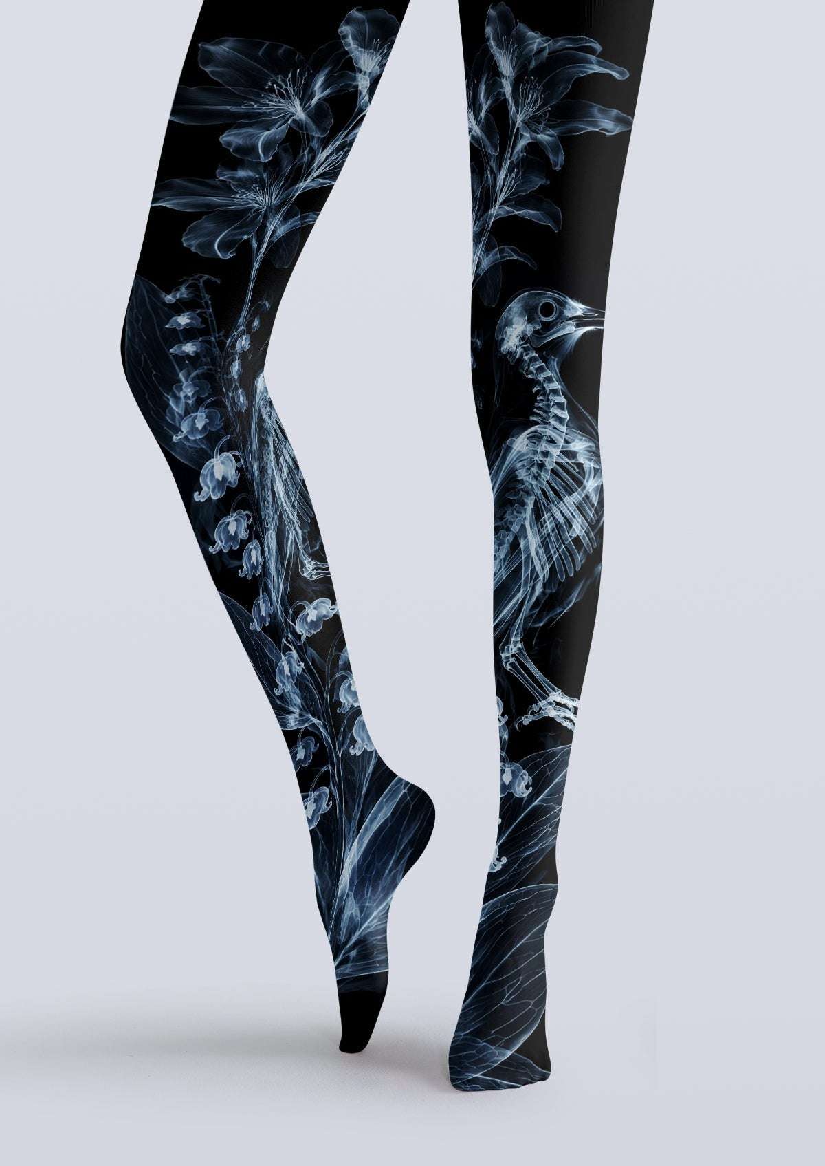 Avaeri black high-stretch tights featuring a blue X-ray style print of bird skeletons and lily-of-the-valley flowers, showcasing an avant-garde Gothic aesthetic.
