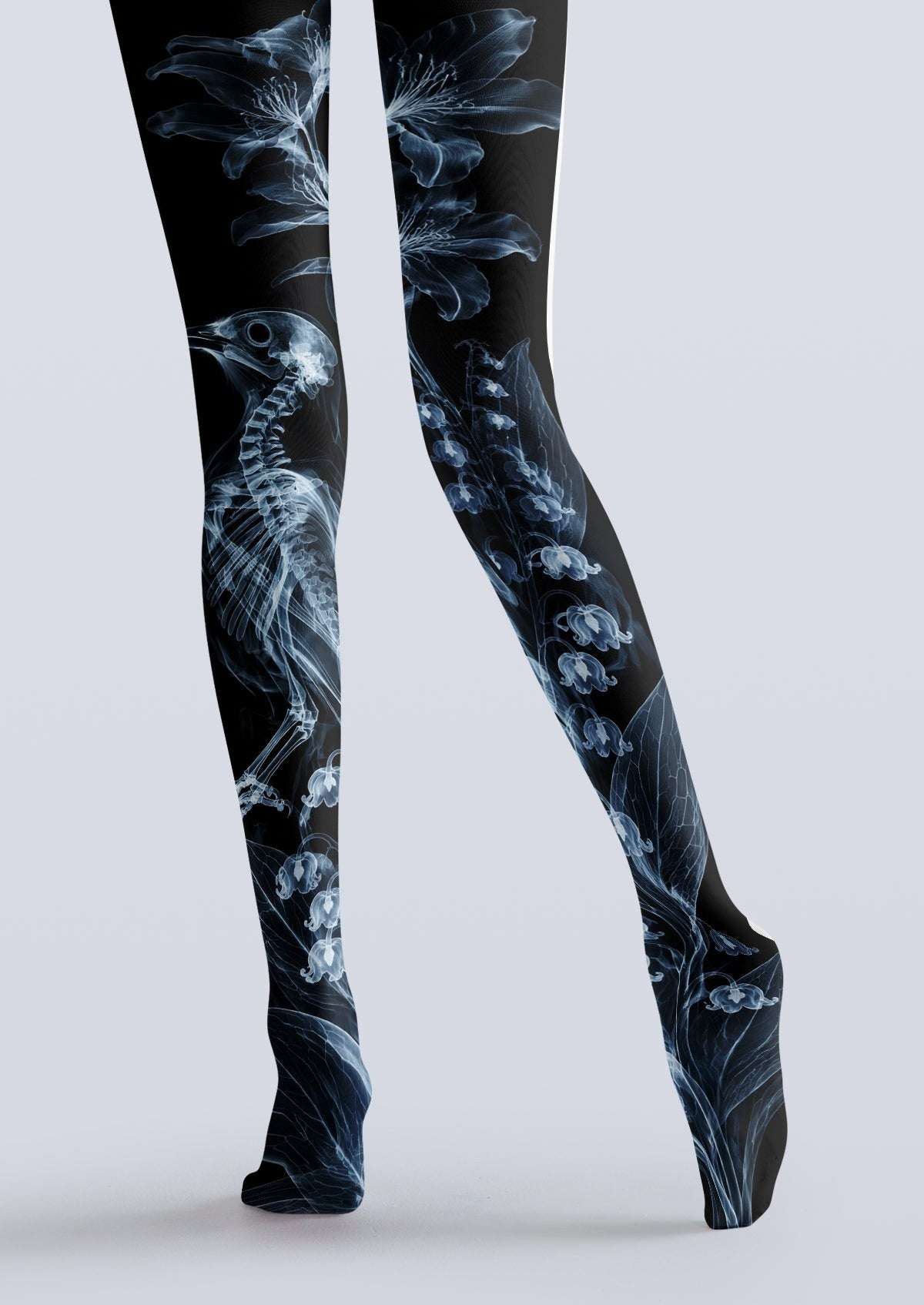 Avaeri black high-stretch tights featuring a blue X-ray style print of bird skeletons and lily-of-the-valley flowers, showcasing an avant-garde Gothic aesthetic.
