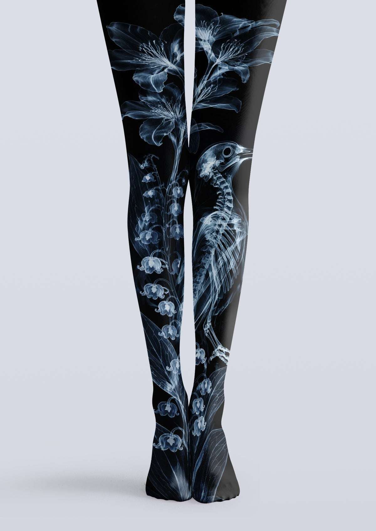 Avaeri black high-stretch tights featuring a blue X-ray style print of bird skeletons and lily-of-the-valley flowers, showcasing an avant-garde Gothic aesthetic.